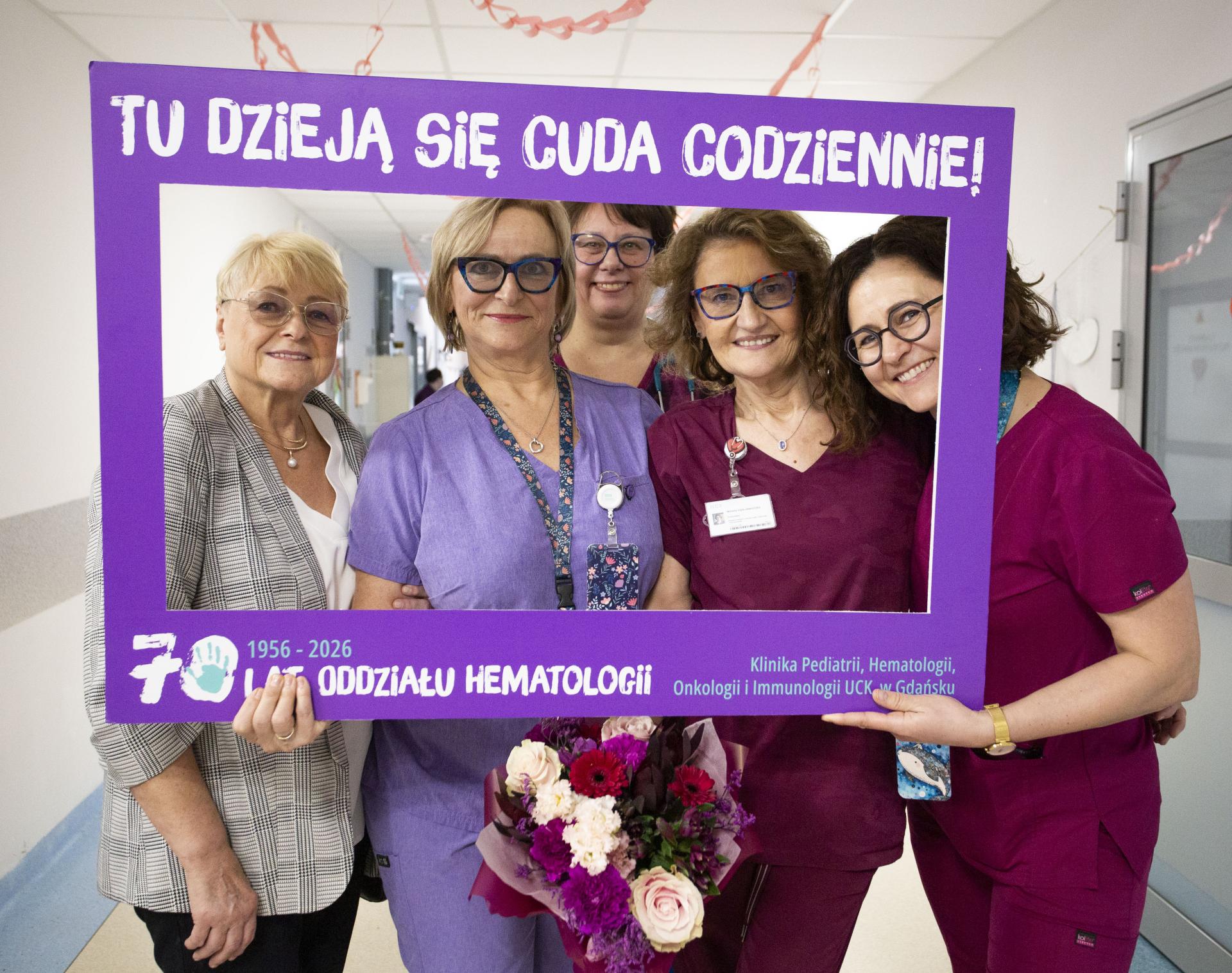Personel kliniki w jubileuszowej ramce z napisem „Tu dzieją się cuda codziennie”