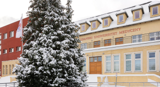 Budynek Atheneum Gedanense Novum GUMed zimą, z ośnieżonym drzewem przed wejściem